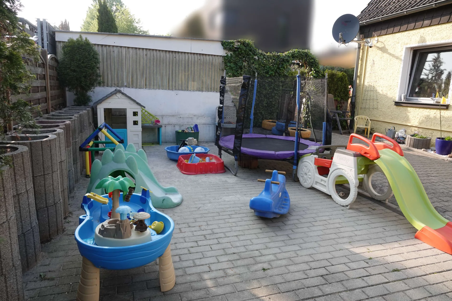 Großer, gesicherter Garten mit Rutschen, Trampolin und Fahrzeugen